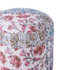 Close-up view of a round pouf featuring vibrant floral and paisley patchwork designs in pink, blue, and gold tones on a white base.