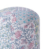 Close-up of a round pouf showcasing intricate floral patchwork in vibrant colors like pink, blue, green, and yellow on a white base.