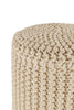 Close-up of a beige knitted pouf showcasing its intricate and tightly woven texture, ideal for adding warmth and style to any room.