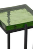 Close-up of a square green glass accent table with a textured surface, supported by a sleek black iron frame, showcasing modern design.