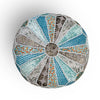 Top view of a round patchwork pouf showcasing intricate blue, teal, and orange patterns with stitched details and a central design.