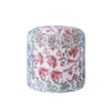 Colorful round pouf featuring floral and paisley patchwork in shades of pink, blue, and green, with intricate detailing on a white base.