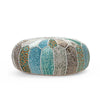 Side view of a round patchwork pouf with vibrant blue, teal, and orange patterns, stitched detailing, and a soft, textured surface.