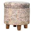 Vintage-inspired storage ottoman with muted multicolor patterns, sturdy wooden legs, removable lid, ideal for compact spaces.