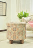 Round brown ethnic storage ottoman with bold patterns, featuring sturdy bamboo legs, ideal for adding vintage charm to your home.