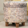 Round vintage-patterned storage ottoman with muted multicolor tones, wooden legs, removable lid, perfect for versatile storage.