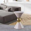 Taupe accent table with a golden center sphere placed on a gray rug in a modern living room with a minimalist taupe sofa and wood flooring.