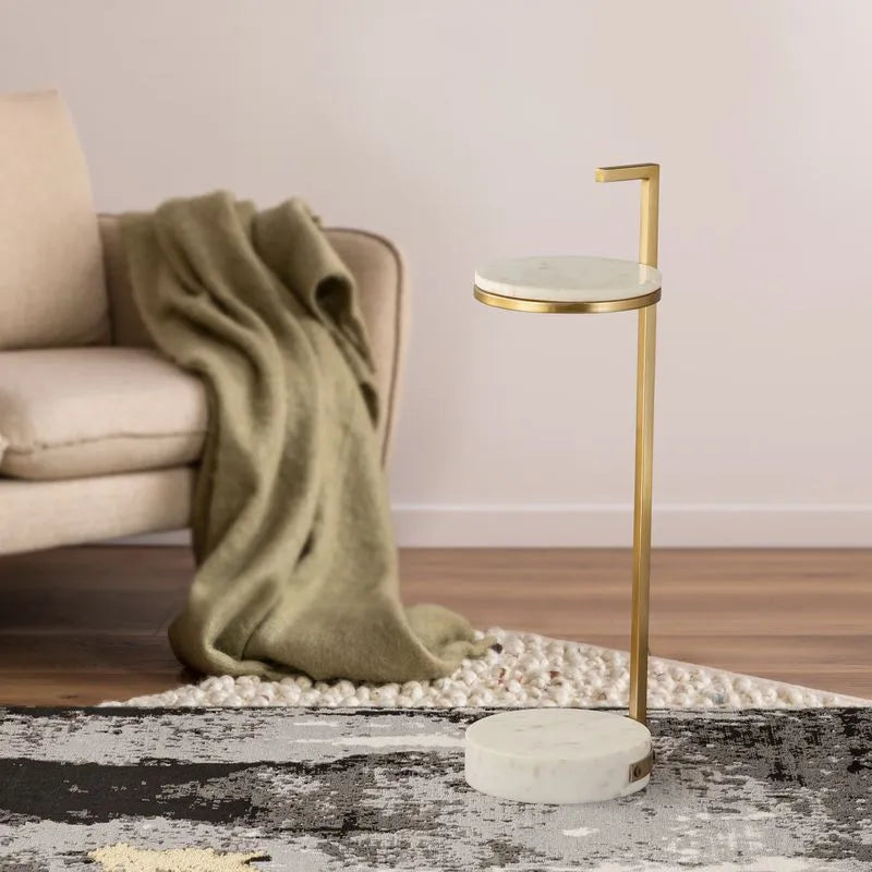 Gold-framed side table with a sleek marble base placed next to a cozy couch, adding a touch of elegance to the living space.