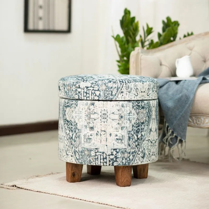 Round blue and white storage ottoman with intricate vintage patterns and sturdy wooden legs, creating a cozy accent for living spaces.