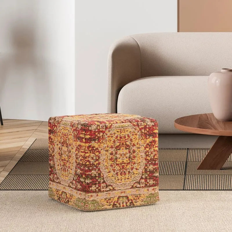 Vintage-style red and yellow patterned cube pouf placed in a cozy living room setting, enhancing home decor with warm tones.