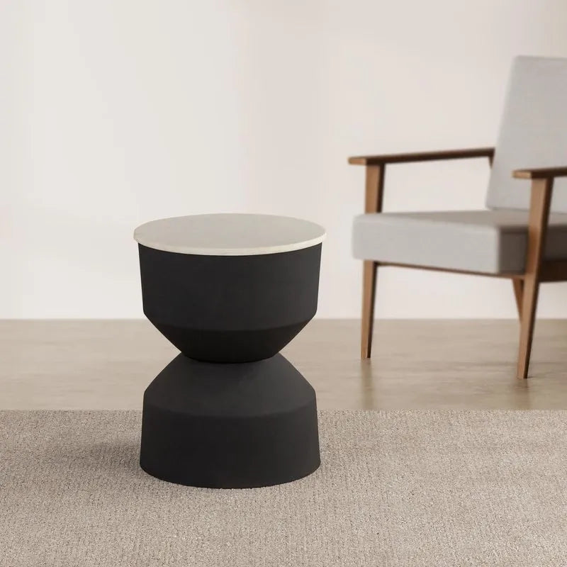 Black modern drink table with a white top, placed in a room with a gray chair, showcasing its sleek design.